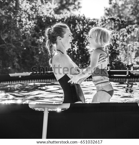 Fun weekend alfresco. happy healthy mother and child in swimsuit in the swimming pool playing