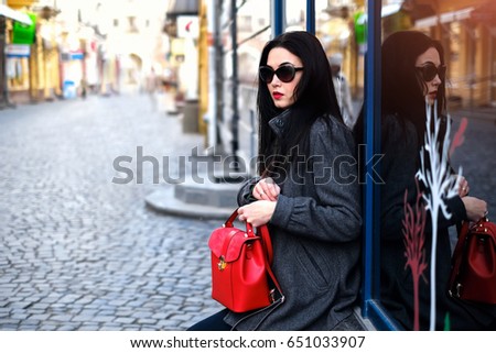 Woman on the street with red backpack in hands