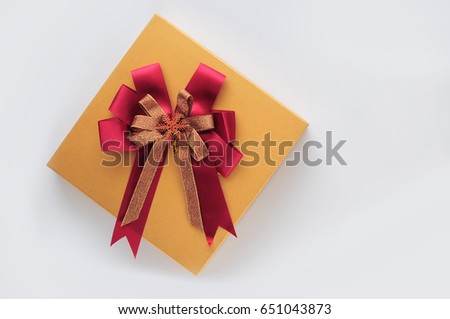 Top view of yellow gift box with red ribbon on white background, holiday and event concept