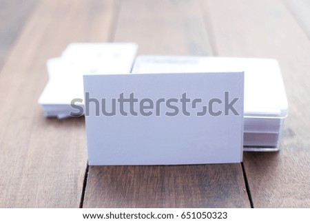 Business card and a clear plastic box placed on a wooden floor