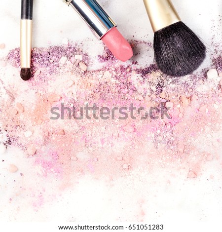Makeup brushes and lipstick on a white background, with traces of powder and blush on it. A square template for a makeup artist's business card or flyer design, with copy space