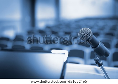 Rostrum with microphone and computer in conference hall Royalty-Free Stock Photo #651052465