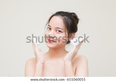 cute Asian girl scrub facial cleansing foam on her face for good health skin  Royalty-Free Stock Photo #651060055