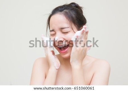 cute Asian girl scrub facial cleansing foam on her face for good health skin  Royalty-Free Stock Photo #651060061