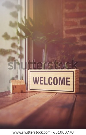 Welcome sign on the wooden table by the window. Vintage style