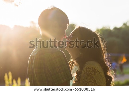 Closeup photo of romantic couple outdoors, side view.