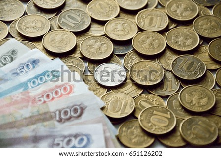 coin with symbol of russian ruble and banknotes on the yellow coins background