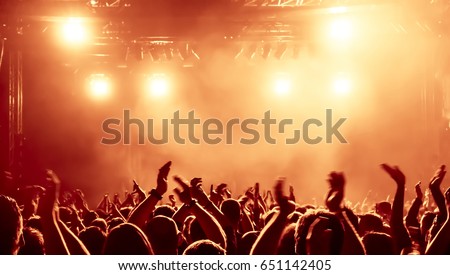 silhouettes of concert crowd in front of bright stage lights Royalty-Free Stock Photo #651142405