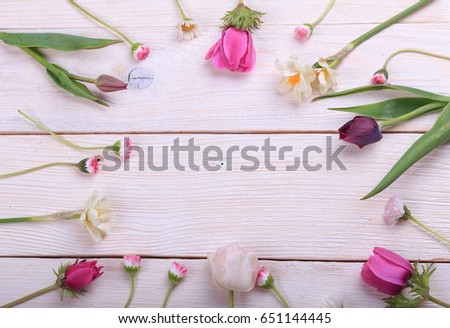 Festive flower composition on the white wooden background. Overhead view. Pink and white anemones, tulips, daisies, daffodils, wildflowers. Mother's, Valentines, Women's Wedding Day concept.