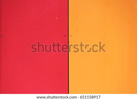 The wall of the house, trimmed with colorful panels, painted in bright colors. Red and orange