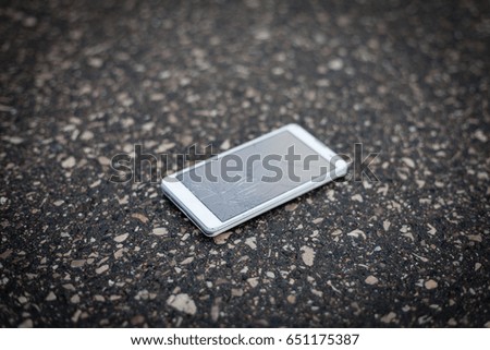 Phone with broken screen lying on the street