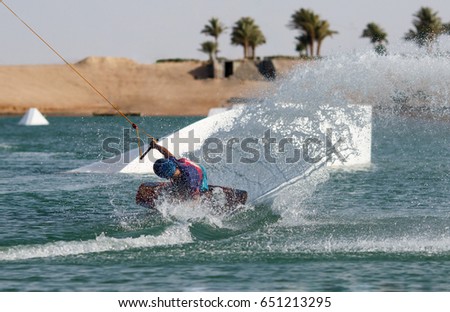 Wake boarding sportsman makes huge water splash in the wake cable park, water sports activities, recreational hobby and fun, active healthy lifestyle and extreme action, summer time