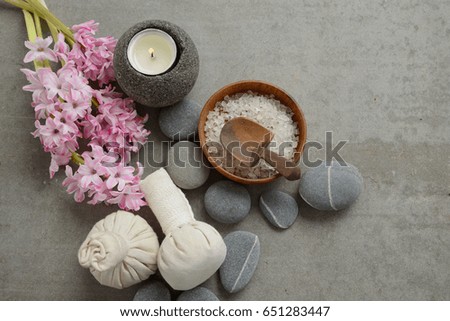 spa setting with Hyacinth flowers,ball,candle,stones, salt in bowl on gray background