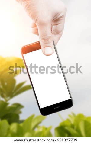 Man uses his Mobile Phone outdoor, close up, capture the moment by a smart phone in my hands. nature background. green background.