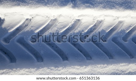   traces of the tread of a truck on snow in the winter season. The picture is taken from above and close-up.