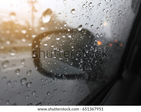 Water drops on a window in the heavy rain. View of car on the street.