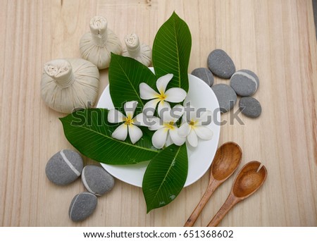 Spa setting with green leaf ,stones, spoon ,ball on wooden background