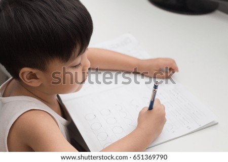 asian boy doing his homework at his desk