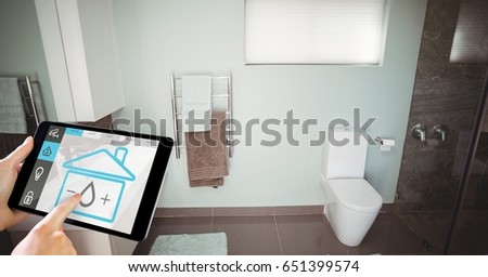 Digital composite of Hand using smart home application on digital tablet in washroom