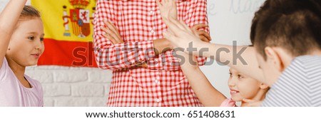 Smart kids rising their hands during spanish classes