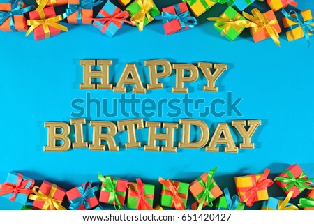 Happy birthday golden text and colorful gifts on a blue background
