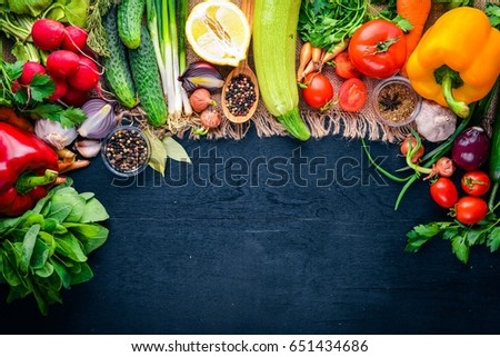 Frame of organic food. Fresh raw vegetables and spices. On a wooden chalkboard.
