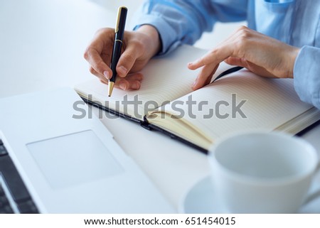 Woman working, woman writing in notebook                               