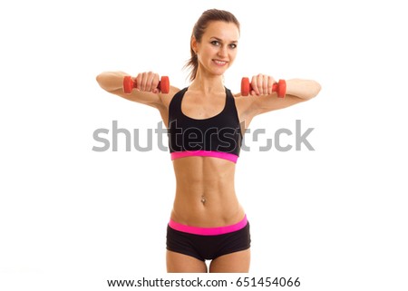 beautiful happy girl smiling sportswear stands up straight and holding a dumbbell
