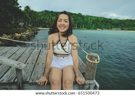 beautiful woman and happy time in holiday by sit on the walkway wood in sea and evening time with smile a happy so good