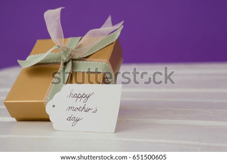Happy mothers day card with gift box on wooden surface