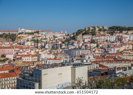 Cityscape. Aerial romantic view of Lisbon town with Castle on a top of a hill against a blue sky background.