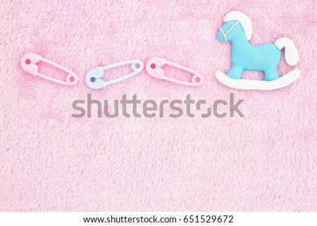 Old fashion pink baby background with baby diaper pins and a rocking horse