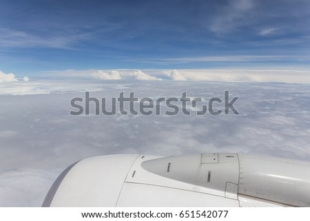 Cloudscape view from airplane window, Blue sky with white fluffy clouds in sunny day.