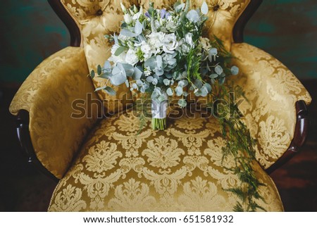 A bridal bouquet of natural flowers lies in a chair