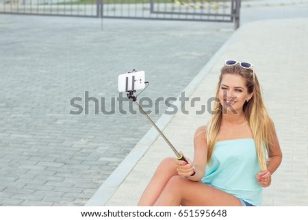 Summer portrait of young beautiful woman. Girl is photographed on the phone. Girl talking on the phone.