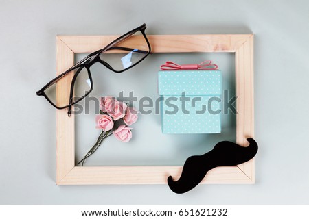 Fathers day. Homemade gift box, the symbols of Father's Day-glasses, mustaches, roses. CONCEPT WELCOME AND GIFTS. Composition in a frame.
