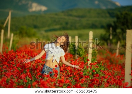 Beautiful woman in a poppy field