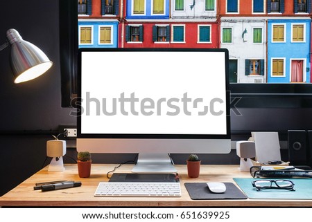 Graphic designer's workspace with a pen tablet, a computer and white backgroud for text with beautiful view of burano from Window 