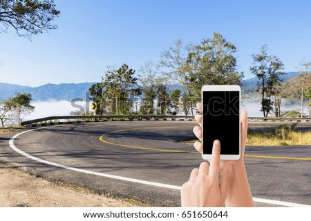 woman use mobile phone and the curved road and sea mist on the mountain