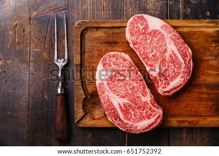 Raw fresh marbled meat Steak Ribeye Black Angus and meat fork on wooden background copy space Royalty-Free Stock Photo #651752392