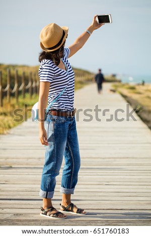 young woman taking photo in the countryside