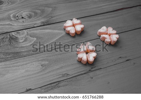 Flowers  from pink marshmallows on  wooden background that converted color to black and white tone but still color flowers