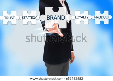 business man hand pressing a touch screen button, BRAND Collaboration Jigsaw Puzzle Concept. Businessman pressing 'BRAND' button on virtual touch screen on blue technology background