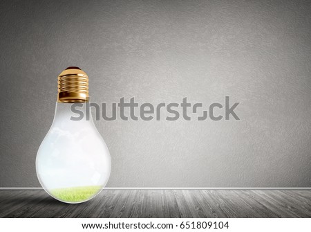 Glass light bulb in concrete empty room. Eco concept