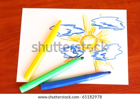 Child's drawing and pens on the table
