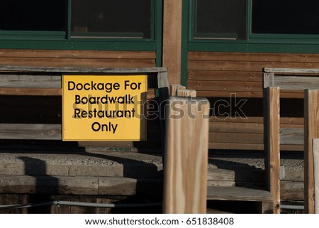 Information sign providing guidance to diners about permissions for docking their boat at the restaurant dock.
