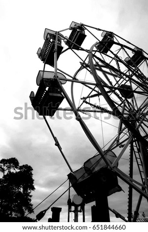 Dramatic image of and empty carnival ride. Heavy filter and vignetting. Dark edges. Low angle.
High contrast.
