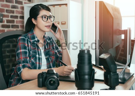 beautiful young female photo design editor holding mobile cell phone talking with company and using digital pad technology pen drawing retouch photo.