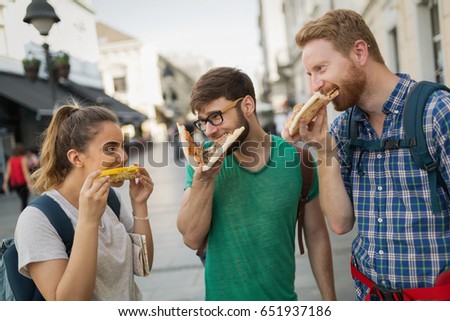 Happy people eating fast food in city