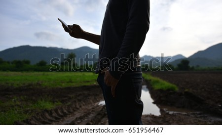 Lowkey,silhouette,Portrait, Man with cellphone ,soft and blur of countryside background. Royalty-Free Stock Photo #651956467